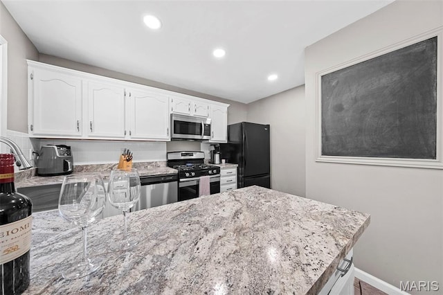 2917 Royal Gorge Ct, Oakville Township, MO 63129 - kitchen with stainless steel appliances, white cabinets, light stone counters, and recessed lighting