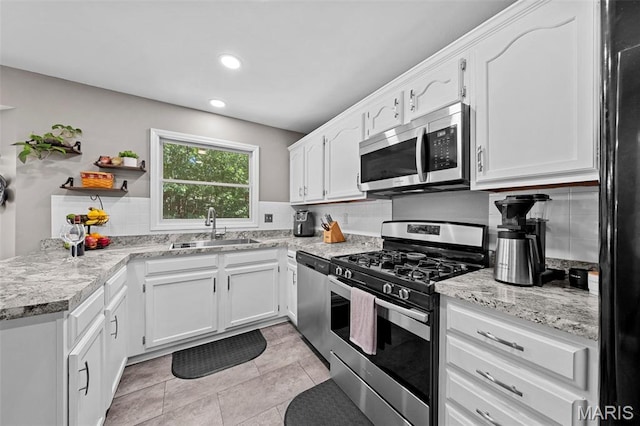 2917 Royal Gorge Ct, Oakville Township, MO 63129 - kitchen featuring appliances with stainless steel finishes, a sink, white cabinets, decorative backsplash, and light tile patterned floors