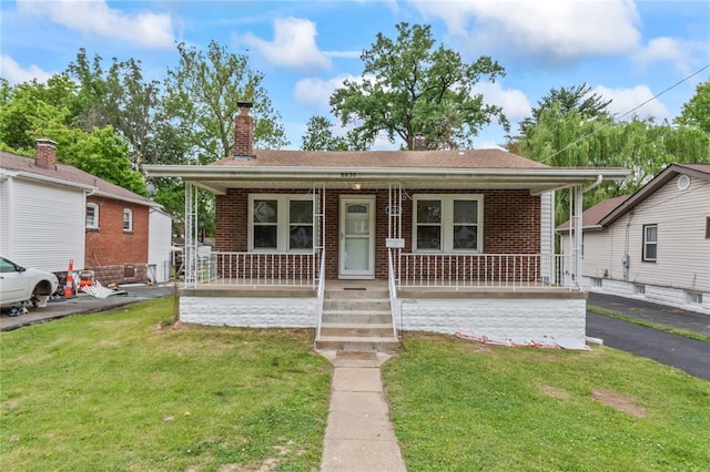 8838 Argyle Ave, Overland, MO 63114 - view of front of home featuring a porch, brick siding, a front yard, and a chimney