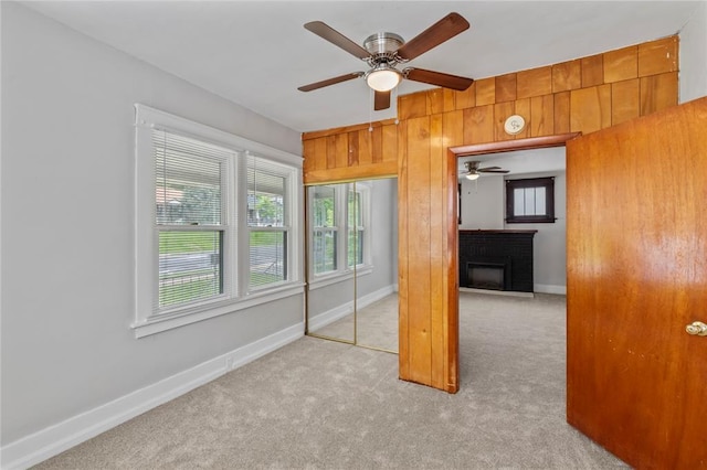 8838 Argyle Ave, Overland, MO 63114 - unfurnished bedroom with carpet flooring, a fireplace, wood walls, a closet, and baseboards