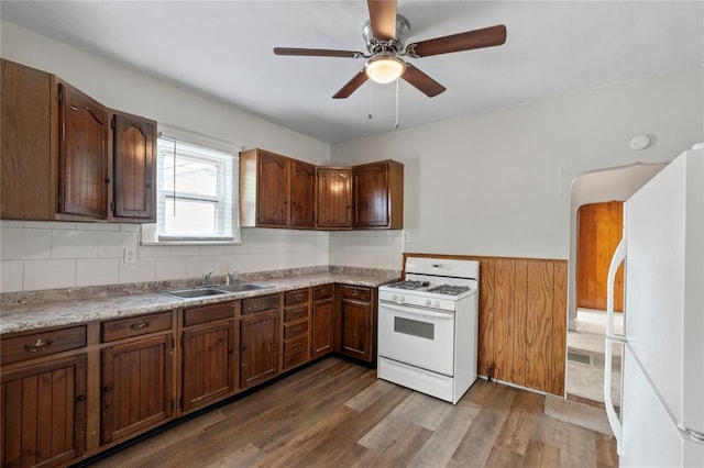 8838 Argyle Ave, Overland, MO 63114 - kitchen with white appliances, a sink, dark wood-type flooring, wainscoting, and a ceiling fan