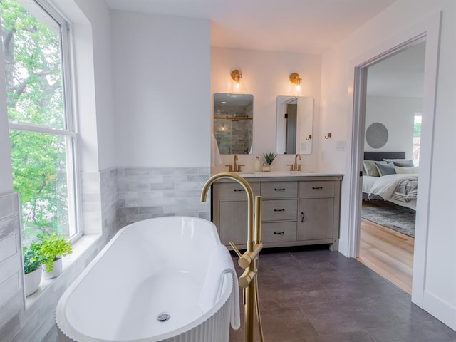 6343 Tholozan, Saint Louis, MO 63109 - full bathroom featuring double vanity, tile walls, a freestanding tub, a shower with door, and wainscoting