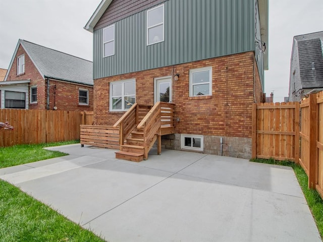 6343 Tholozan, Saint Louis, MO 63109 - back of house with a patio, board and batten siding, a fenced backyard, and brick siding