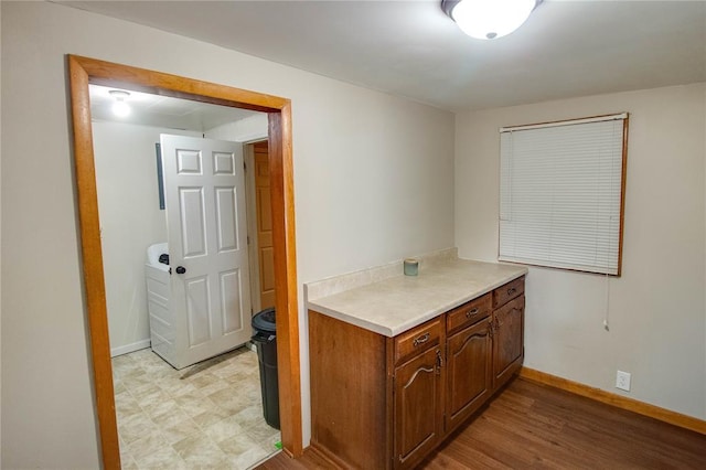 155 Roberts St, Jerseyville, IL 62052 - kitchen featuring light countertops, baseboards, light wood finished floors, and brown cabinetry