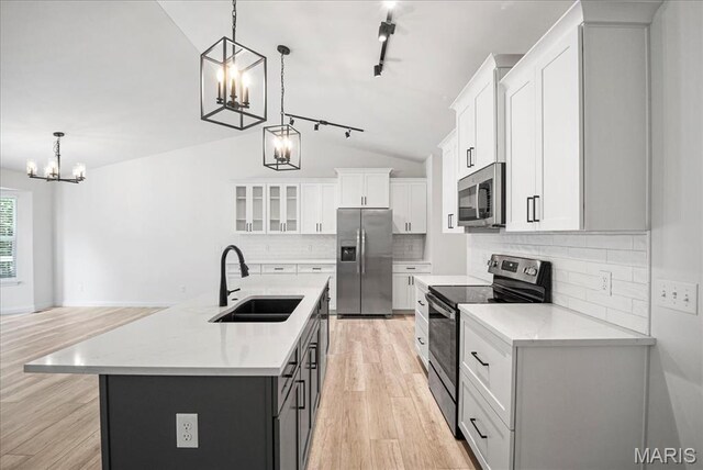346 Fairhaven Ct, Wright City, MO 63390 - kitchen featuring stainless steel appliances, a chandelier, light wood-type flooring, vaulted ceiling, and white cabinetry