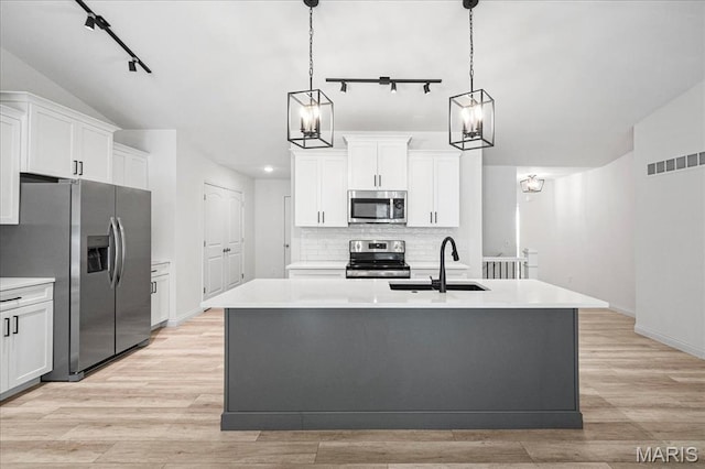346 Fairhaven Ct, Wright City, MO 63390 - kitchen with appliances with stainless steel finishes, track lighting, vaulted ceiling, backsplash, and light countertops