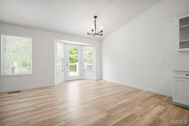 346 Fairhaven Ct, Wright City, MO 63390 - unfurnished dining area featuring a chandelier, light wood-style floors, plenty of natural light, and vaulted ceiling