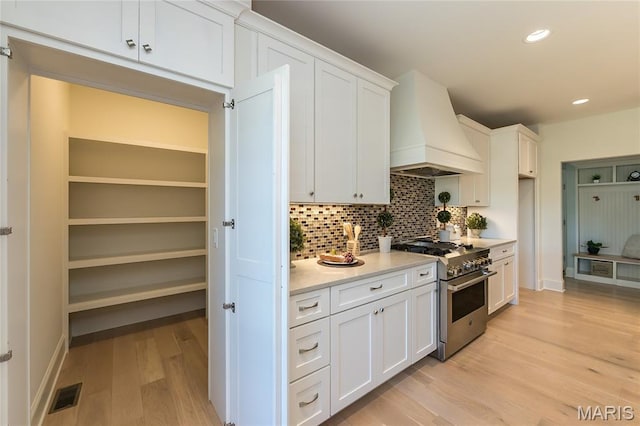 111 N Mosley Rd, Saint Louis, MO 63141 - kitchen with high end range, custom range hood, light countertops, backsplash, and white cabinets