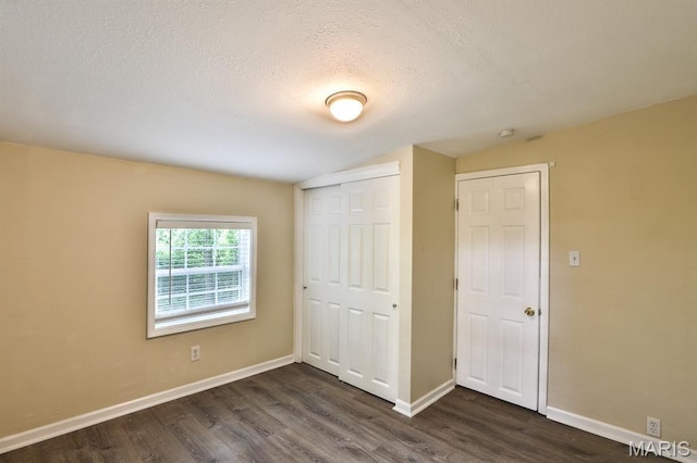 542 Meramec Station Rd Unit C, Valley Park, MO 63088 - unfurnished bedroom featuring dark wood finished floors, a closet, a textured ceiling, baseboards, and lofted ceiling