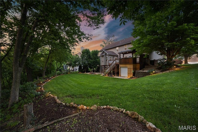 1171 Red Hawk Ridge Ln, Ofallon, IL 62269 - yard at dusk featuring stairs, a garage, a yard, and a wooden deck