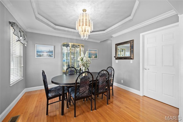 1171 Red Hawk Ridge Ln, Ofallon, IL 62269 - dining space with a chandelier, light wood finished floors, a raised ceiling, baseboards, and ornamental molding