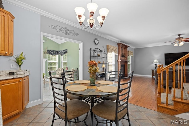 1171 Red Hawk Ridge Ln, Ofallon, IL 62269 - dining room featuring a chandelier, light tile patterned floors, crown molding, a fireplace, and a ceiling fan