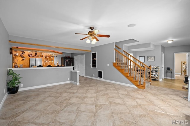 1171 Red Hawk Ridge Ln, Ofallon, IL 62269 - unfurnished living room with stairs, a ceiling fan, baseboards, and bar area