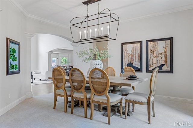 4388 Austin Pass Dr, Saint Charles, MO 63304 - dining space featuring arched walkways, decorative columns, crown molding, light carpet, and a chandelier