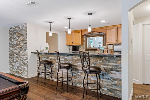 4388 Austin Pass Dr, Saint Charles, MO 63304 - kitchen featuring dark wood-style flooring, arched walkways, a kitchen breakfast bar, and decorative light fixtures