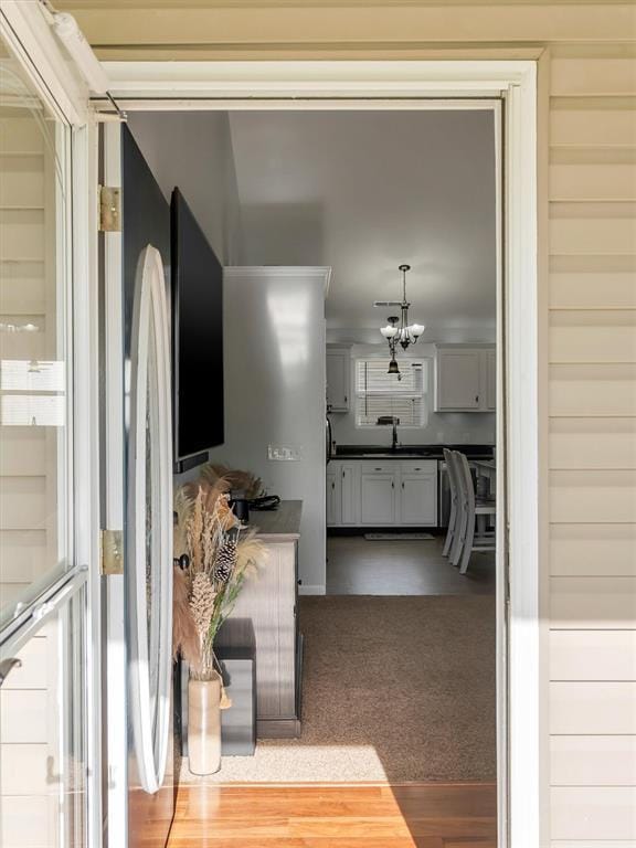 109 N 7th St, Owensville, MO 65066 - corridor featuring a sink, wood finished floors, and a chandelier