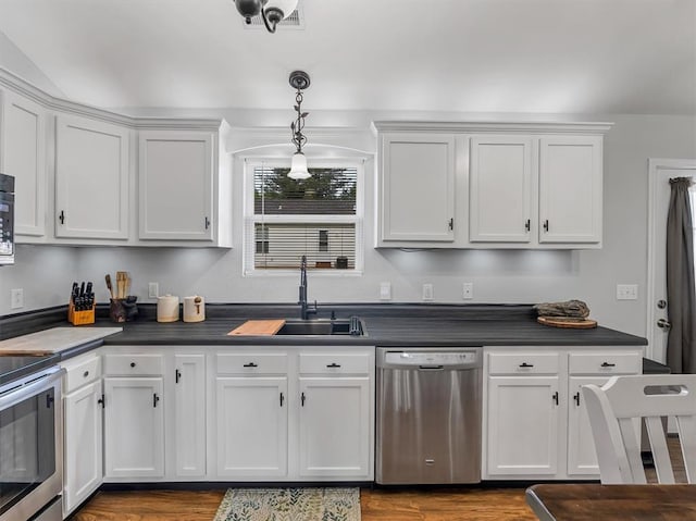 109 N 7th St, Owensville, MO 65066 - kitchen with stainless steel appliances, a sink, white cabinets, and dark countertops
