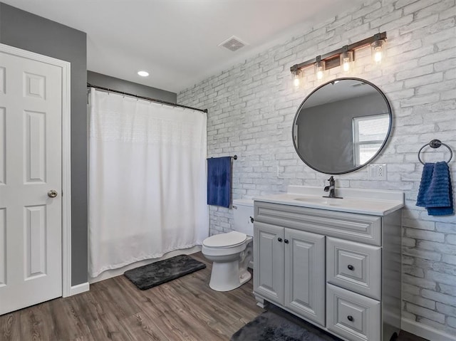 109 N 7th St, Owensville, MO 65066 - full bathroom with brick wall, vanity, toilet, wood finished floors, and a shower with shower curtain