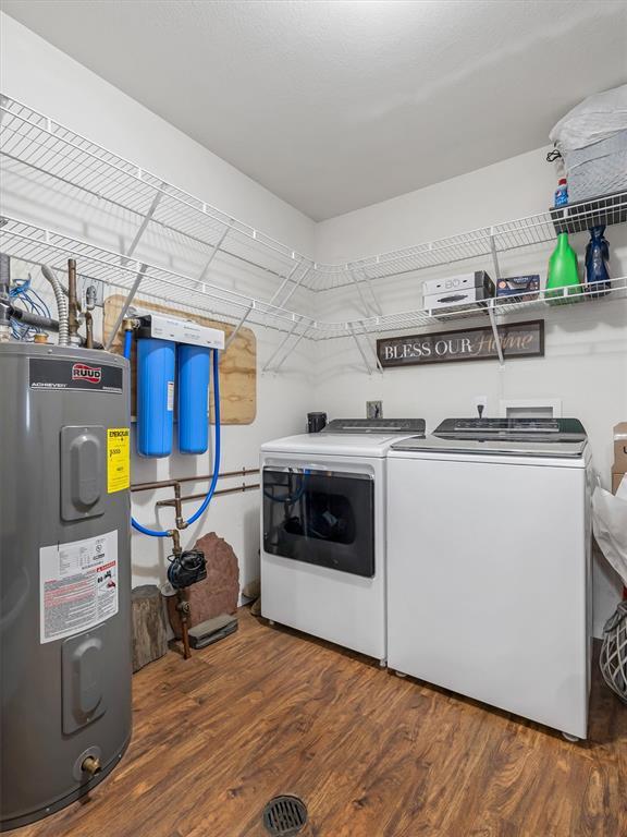 109 N 7th St, Owensville, MO 65066 - laundry room with water heater, washer and clothes dryer, and wood finished floors