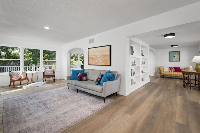 1594 Rue Calais, Bonne Terre, MO 63628 - living area featuring wood finished floors, arched walkways, a textured ceiling, recessed lighting, and baseboards