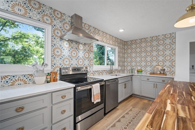 1594 Rue Calais, Bonne Terre, MO 63628 - kitchen with wall chimney range hood, stainless steel appliances, a sink, wooden counters, and wallpapered walls