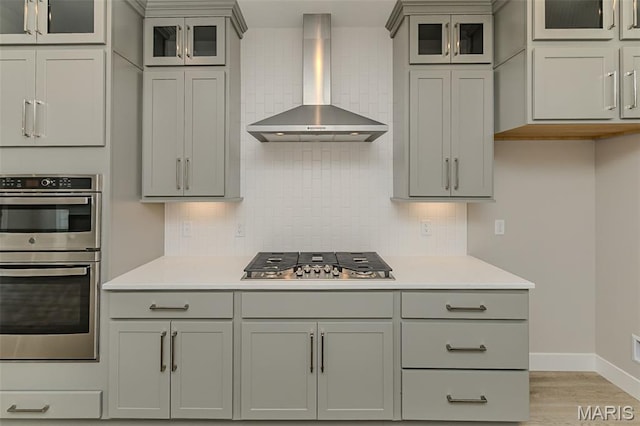 8919 E Gateway Hts Unit 94-804, Richmond Heights, MO 63144 - kitchen with wall chimney range hood, stainless steel appliances, light wood-type flooring, and gray cabinetry