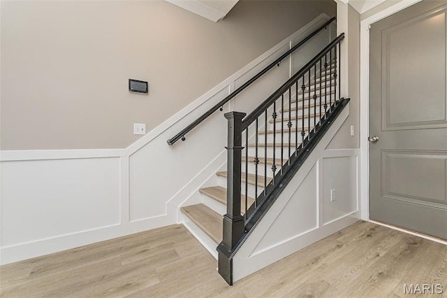 8919 E Gateway Hts Unit 94-804, Richmond Heights, MO 63144 - stairway featuring a decorative wall, wood finished floors, and wainscoting