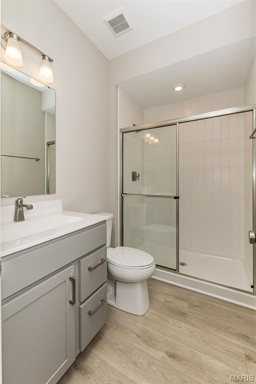 8919 E Gateway Hts Unit 94-804, Richmond Heights, MO 63144 - full bath with toilet, vanity, a shower stall, and wood finished floors