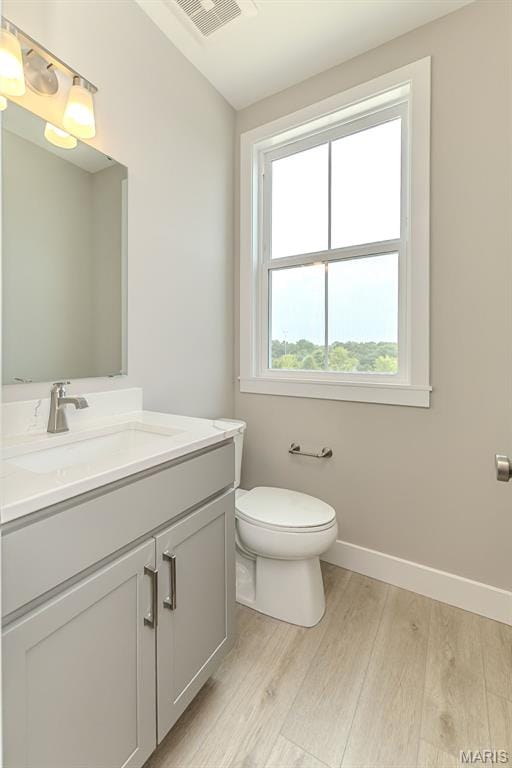 8919 E Gateway Hts Unit 94-804, Richmond Heights, MO 63144 - bathroom featuring wood finished floors, vanity, toilet, and baseboards