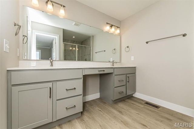 8919 E Gateway Hts Unit 94-804, Richmond Heights, MO 63144 - bathroom featuring double vanity, a stall shower, and wood finished floors