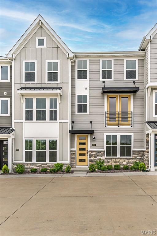 8919 E Gateway Hts Unit 94-804, Richmond Heights, MO 63144 - townhome / multi-family property with stone siding and a standing seam roof