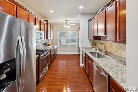 754 Michael St, Ofallon, IL 62269 - kitchen with stainless steel appliances, a sink, ceiling fan, backsplash, and dark wood finished floors