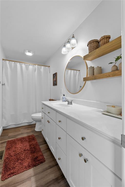 170 Parklane Dr, Cape Girardeau, MO 63701 - bathroom with vanity, toilet, wood finished floors, and curtained shower