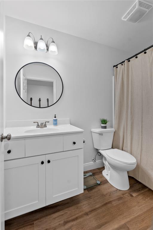 170 Parklane Dr, Cape Girardeau, MO 63701 - full bath with toilet, vanity, wood finished floors, baseboards, and curtained shower
