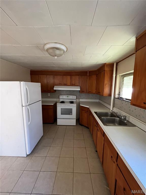 10052 Valley Dr, Riverview, MO 63137 - kitchen with white appliances, a sink, under cabinet range hood, brown cabinets, and light countertops