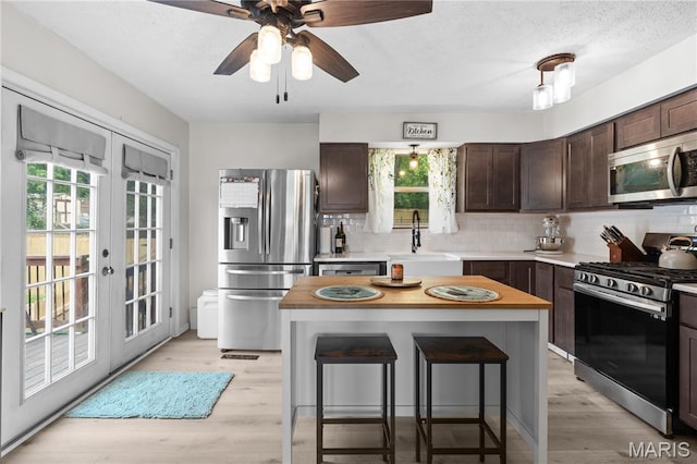 1998 Ridgeway Dr, Arnold, MO 63010 - kitchen with appliances with stainless steel finishes, a sink, dark brown cabinets, and plenty of natural light