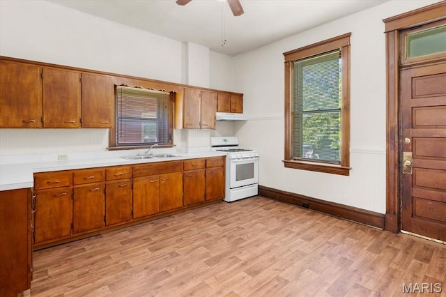 207 Voss Pl, Belleville, IL 62220 - kitchen with white gas range, a sink, brown cabinets, and light countertops