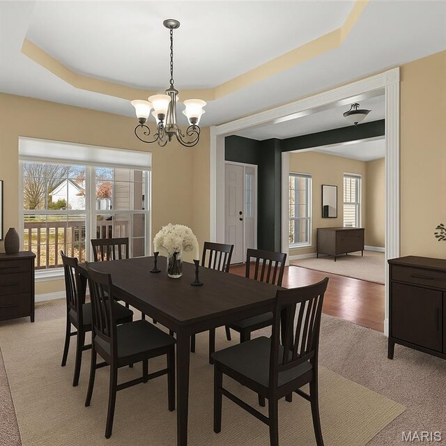122 Tennessee Walker Way, Saint Peters, MO 63376 - dining room with light colored carpet, a tray ceiling, a chandelier, and plenty of natural light