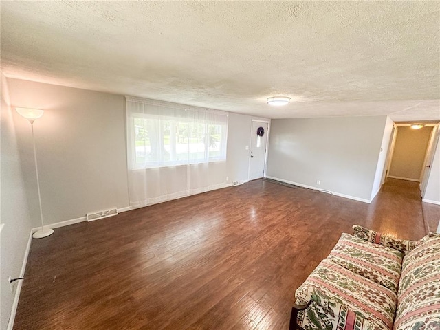 1110 W 3rd St, Salem, MO 65560 - unfurnished living room with a textured ceiling, wood finished floors, and baseboards