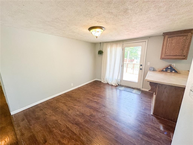 1110 W 3rd St, Salem, MO 65560 - unfurnished dining area featuring dark wood-style floors, a textured ceiling, and baseboards