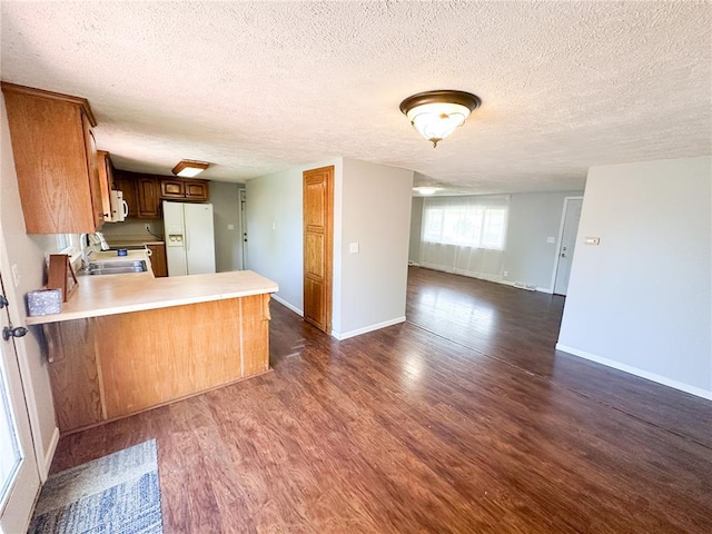 1110 W 3rd St, Salem, MO 65560 - kitchen featuring white appliances, open floor plan, a textured ceiling, dark wood finished floors, and light countertops