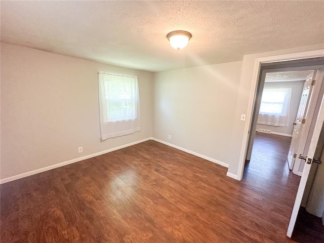 1110 W 3rd St, Salem, MO 65560 - spare room featuring dark wood-style flooring, baseboards, and a textured ceiling