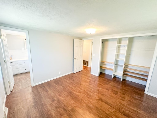 1110 W 3rd St, Salem, MO 65560 - unfurnished bedroom with wood finished floors, a textured ceiling, a closet, and baseboards