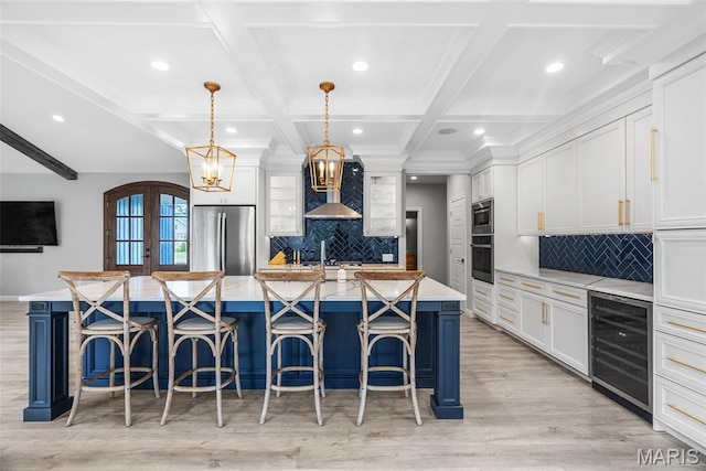 116 Brian Trl, Arnold, MO 63010 - kitchen with wine cooler, stainless steel appliances, recessed lighting, wall chimney exhaust hood, and white cabinets