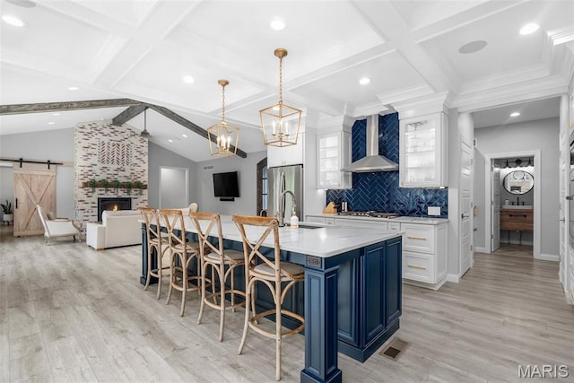 116 Brian Trl, Arnold, MO 63010 - kitchen with wall chimney range hood, a breakfast bar, a spacious island, white cabinetry, and light countertops