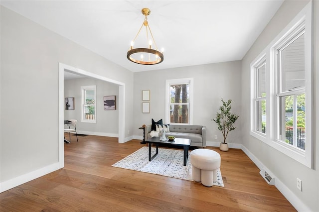 514 S Gore Ave, Saint Louis, MO 63119 - living area with a chandelier, plenty of natural light, wood finished floors, and baseboards