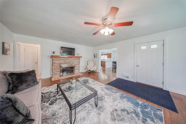 1707 S Mcarthur Ave, Salem, MO 65560 - living room featuring a ceiling fan, wood finished floors, baseboards, and a stone fireplace