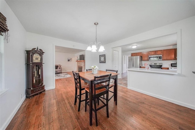 1707 S Mcarthur Ave, Salem, MO 65560 - dining room with wood finished floors, a chandelier, and baseboards