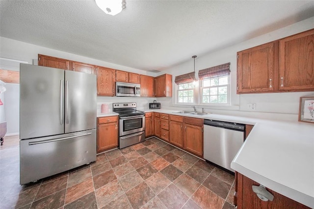 1707 S Mcarthur Ave, Salem, MO 65560 - kitchen featuring stainless steel appliances, a sink, light countertops, stone finish flooring, and brown cabinets