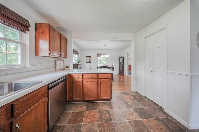 1707 S Mcarthur Ave, Salem, MO 65560 - kitchen featuring dishwasher, a peninsula, a chandelier, light countertops, and brown cabinetry